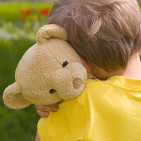 Trauriges Kind mit Teddy